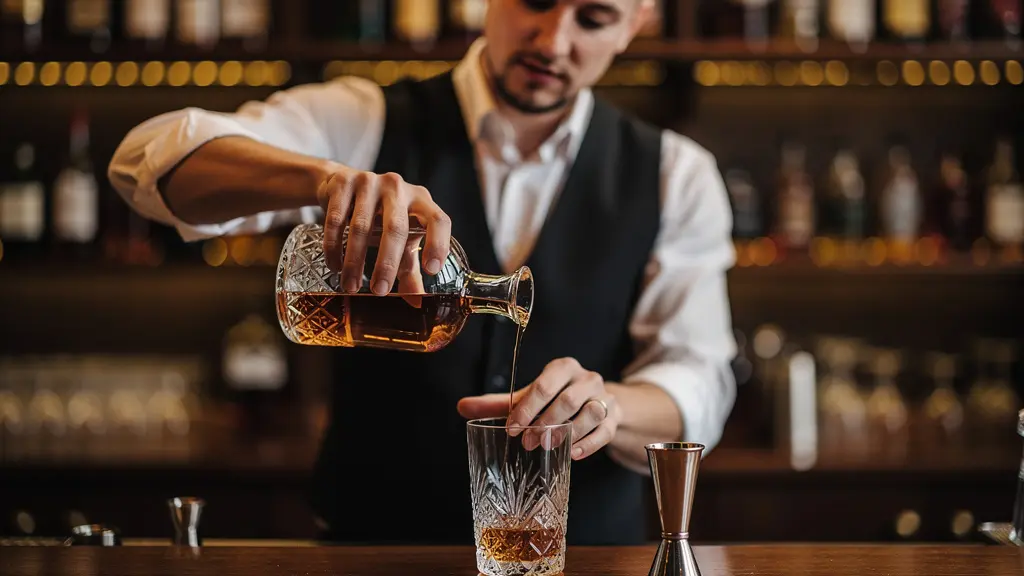 Professional bartender carefully pouring craft spirit in upscale cocktail bar setting